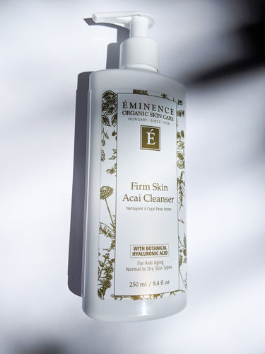 a bottle of firm skin acai cleanser by Eminence. The bottle has a pump top.