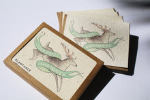 Load image into Gallery viewer, the box set version of the Happy Holidays deer card - it is a set of 8. a plantable seed card - the card has a textured look from the seeds imbedded in the paper. There is a deer drawing on this one that says "HAPPY HOLIDAYS" on a green banner across the deer