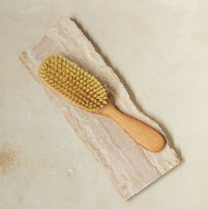 a light colored wooden hair brush with vegan bristles
