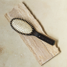 Load image into Gallery viewer, a dark colored wooden hair brush with light wood bristles