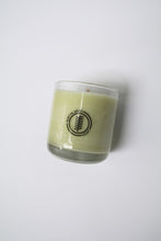 Load image into Gallery viewer, an up close video of a candle - the candle wax is a white color and is inside a clear glass container that doubles as a drinking tumbler once the candle burns out.