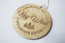 Load image into Gallery viewer, an up close look at a circular wooden ornament that says "Happiest of Holidays from Key West"