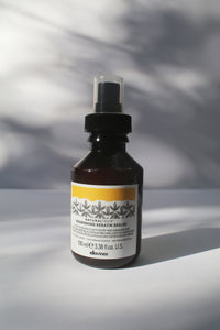 a bottle of "Natural Tech Nourishing Keratin Sealer" by Davines with a spray nozzle lid