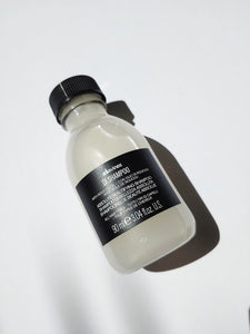 a travel size bottle of oi shampoo by Davines
