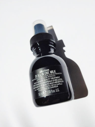 a travel size bottle of oi all in one milk by Davines - the bottle has a spray nozzle