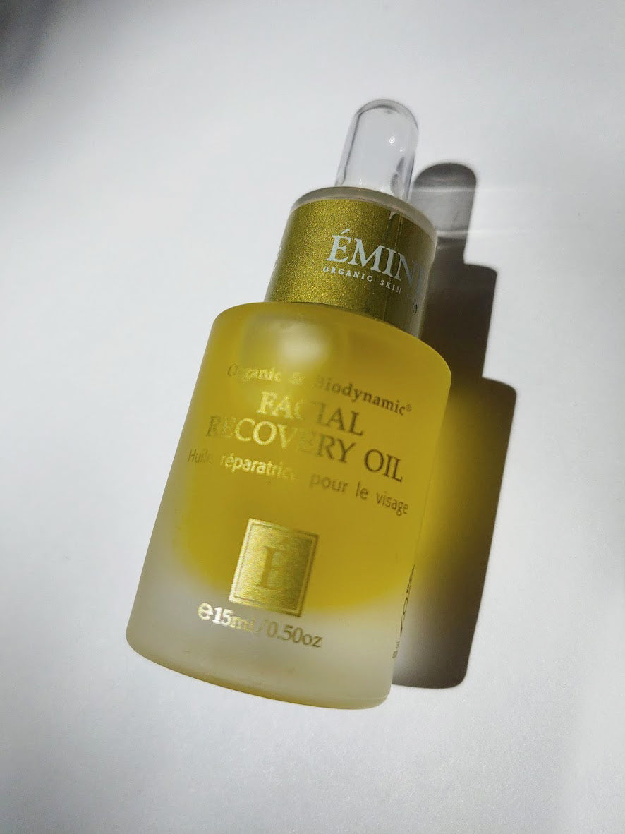 a bottle of facial recovery oil by Eminence. The bottle has a dropper top.