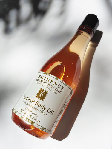 a large bottle of apricot body oil by Eminence - it is a bright peachy color in the glass bottle. for all skin types.