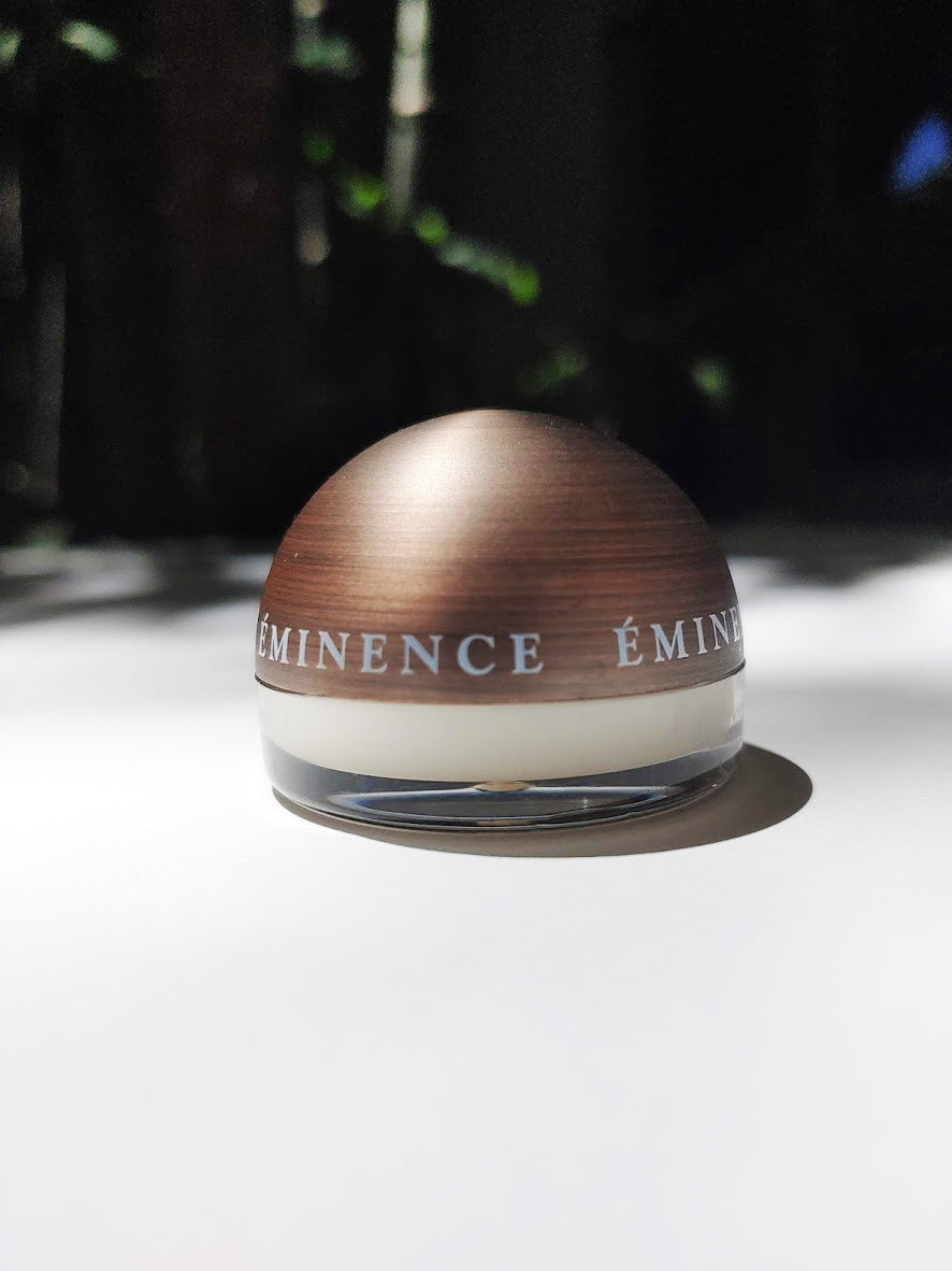 a small jar of lip balm by eminence - the lid of the jar is spherical and a lovely brassy wood color