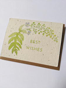 a plantable seed card - the card has a textured look from the seeds imbedded in the paper. There is a leaf illustration with two small purple flowers on this one and it says "BEST WISHES"