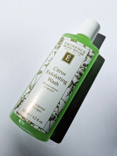 a bottle of Citrus Exfoliating Wash by Eminence. The liquid inside the bottle is a bright lime green color.