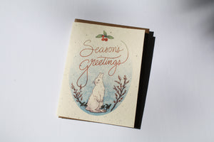 a plantable seed card - the card has a textured look from the seeds imbedded in the paper. There is a bunny drawing on this one that says "Season's Greetings