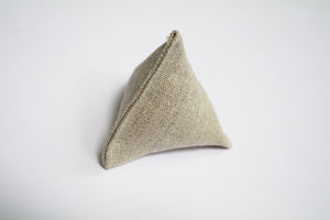 an up close look at a little pyramid made out of hemp. The hemp is a natural light brown color.