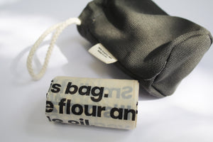 an up close look at the biodegradable poop bags, with the plastic free holder in the background