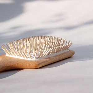 a close up look at the light wood paddle hair brush