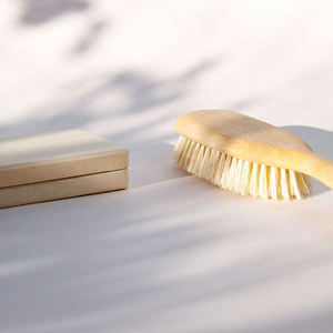 a light colored wooden hair brush with vegan bristles