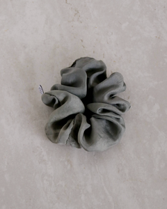 a close up of a gray silk scrunchie