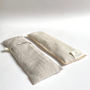 two a natural linen eye pillows, one has the slip cover on it, one does not