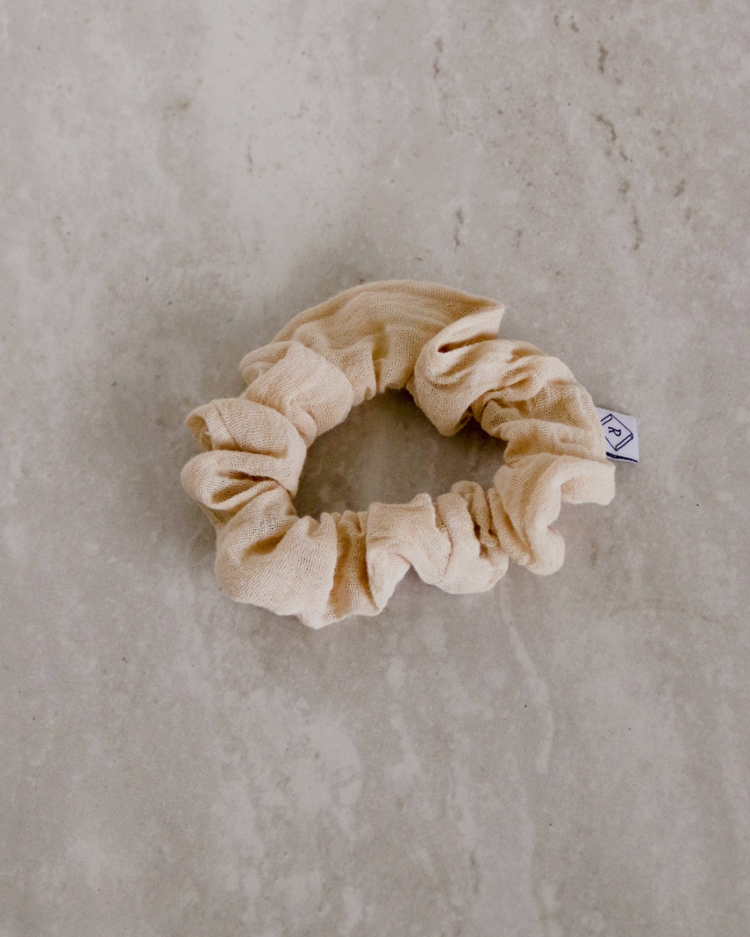 a cream colored gauze scrunchie
