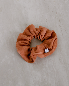 a burnt orange colored gauze scrunchie