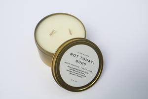 a bug repellent candle with the lid leaning against it