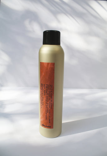 a gold can of dry shampoo by Davines with an orange label