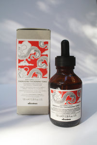 a bottle of "Natural Tech Energizing Thickening Tonic" by Davines with an eyedropper lid