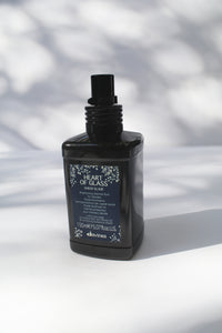 a black jar of "Heart of Glass Sheer Glaze" by Davines - the bottle has a spray nozzle