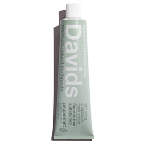 a tube of David's Natural Toothpaste. it says "Premium Natural Toothpaste. Whitening, Antiplaque, Fresh Breath, Flouride Free, Sulfate Free. Peppermint essential oil blend"