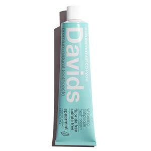 a tube of David's Natural Toothpaste. it says "Premium Natural Toothpaste. Whitening, Antiplaque, Fresh Breath, Flouride Free, Sulfate Free. Spearmint essential oil blend"