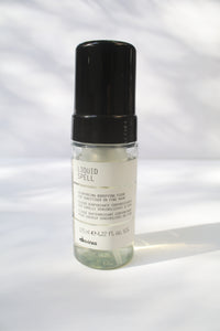 a clear jar of "Liquid Spell" by Davines with a spray pump lid