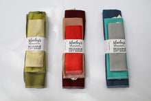 Load image into Gallery viewer, three different color reusable wrapping paper bundles (from left to right: green, red, and blue)
