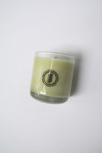Load image into Gallery viewer, an up close video of a candle - the candle wax is a white color and is inside a clear glass container that doubles as a drinking tumbler once the candle burns out.
