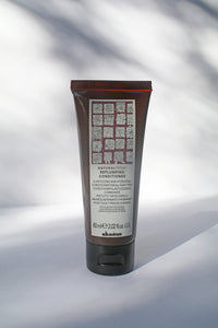 a travel size bottle of "Natural Tech Replumping Conditioner" in travel size by Davines