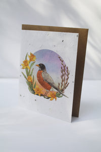 a card with seeds imbedded in the paper to plant and a watercolor robin with yellow flowers on the front
