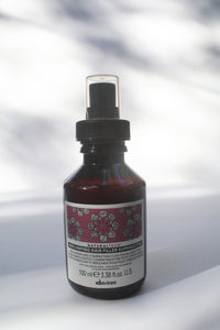 a bottle of "Natural Tech Replumping Hair Filler Superactive" by Davines with a spray nozzle