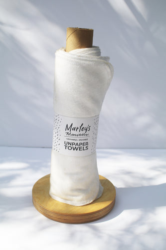 white, rolled unpaper towels on a wooden stand