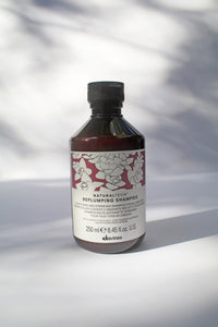 a bottle of "Natural Tech Replumping Shampoo" by Davines